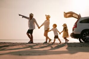 Uma famílias, pai, mãe e duas crinaças aproveitando uma viagem a praia.