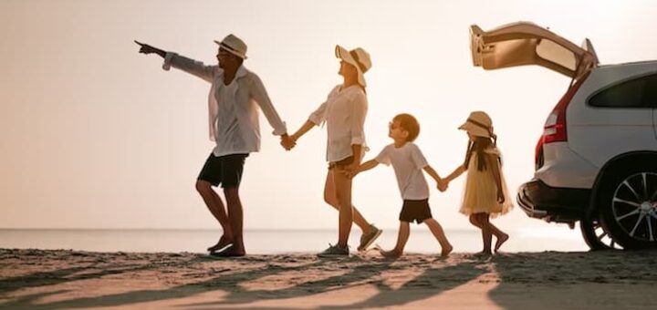 Uma famílias, pai, mãe e duas crinaças aproveitando uma viagem a praia.